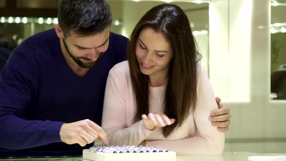 Young Couple Chooses Engagement Rings at the Jewelry Shop