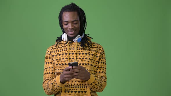 Young Handsome African Man with Dreadlocks Against Green Background