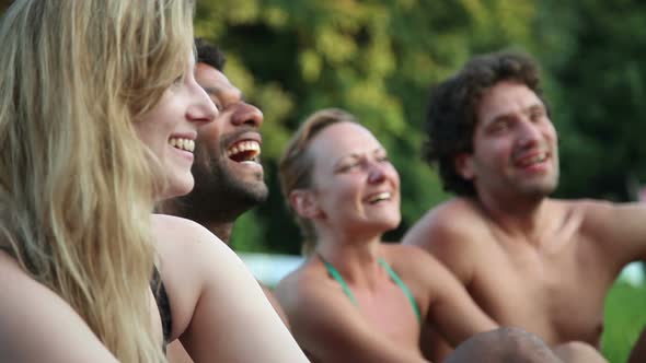 Four friends laughing while sitting in nature