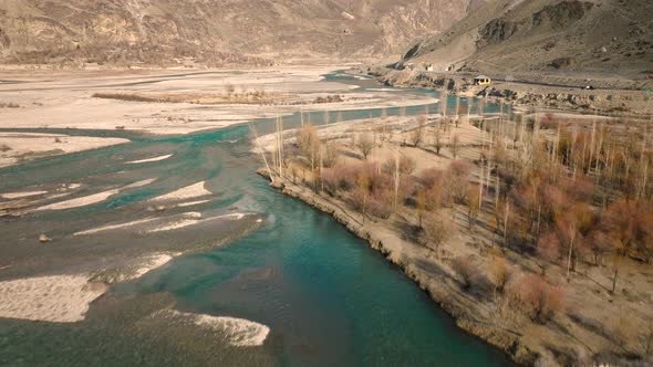 Drone Flying Over Turquoise Winding River Rising To Reveal Sweeping Valley Landscape Of Ghizer Valle