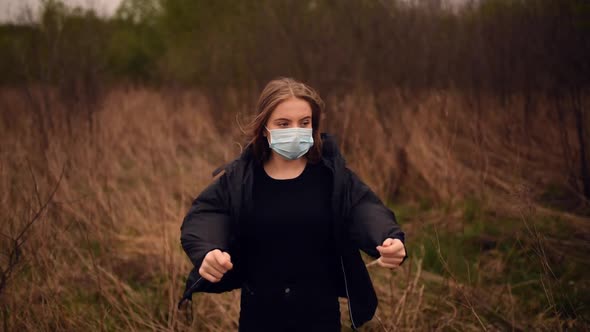 Woman in a Mask Puts on a Jacket at Nature Pandemic Covid19 Coronavirus