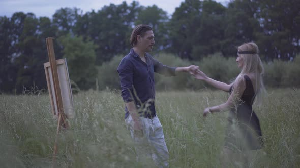 Happy Loving Man and Woman Dancing on Summer Meadow at Dusk. Portrait of Smiling Cheerful Caucasian