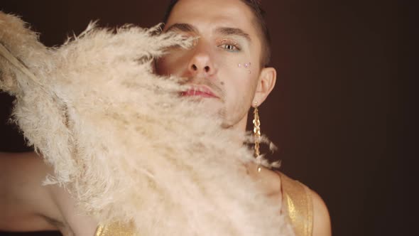 Fashionable Gay Man Posing with Pampas Grass during Photoshoot