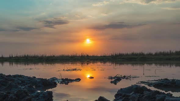 Golden Sunset Over Okavango Delta With Wispy Clouds Reflection On Calm Waters In Botswana - Time Lap