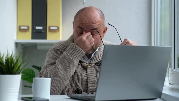 Tired Middle Aged Man in Eyewear Working with Computer Remotely Sitting at Home or in Office