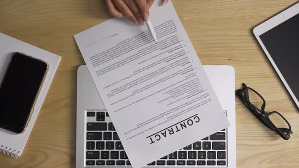 Top View of Female Hands Checking and Signing By Pen a Contract Then Squeeze Paper