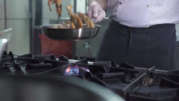 Man Prepares Shrimps in Frying Pan on Gas Stove in Kitchen