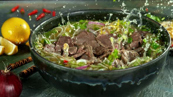 Super Slow Motion Shot of Sliced Beef Falling Into Pho Soup at 1000 Fps.