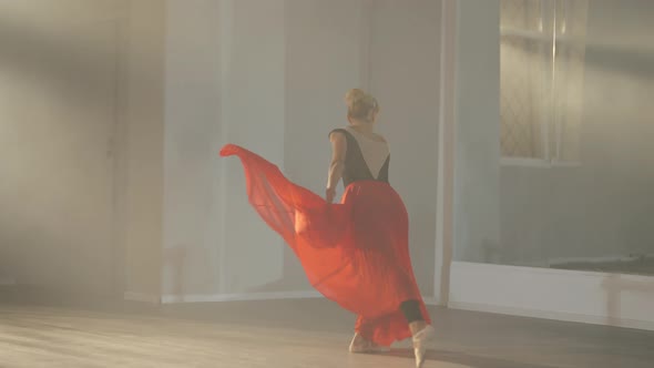 Slim Gorgeous Ballerina in Scarlet Red Skirt Spinning in Slow Motion in Backlit Fog Indoors