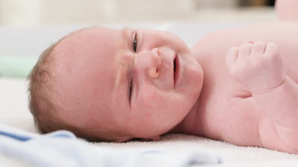 Closeup Portrait of Cute Little Newborn Baby Boy Lying on Changing Table