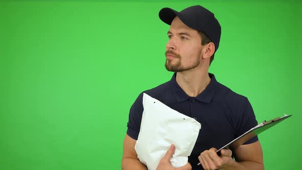 A Young Handsome Mailman Looks Around with a Smile - Green Screen Studio