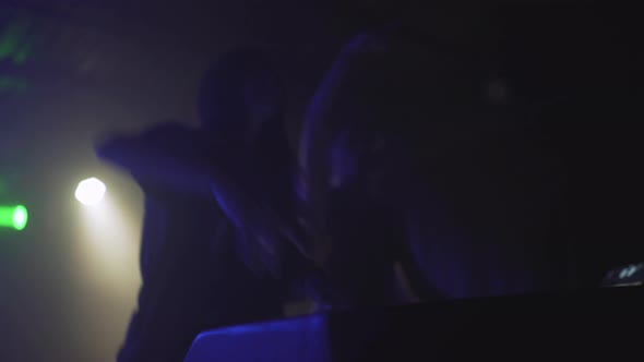 Two Beautiful Young Women DJ Play the Music on the Mixing Console in the Nightclub