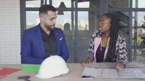 Multicultural Couple Choosing Upholstery and Style of Furniture. Caucasian Man and African American