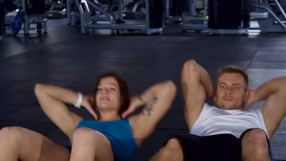 Fitness Man and Woman Train Their Abdominal Muscles
