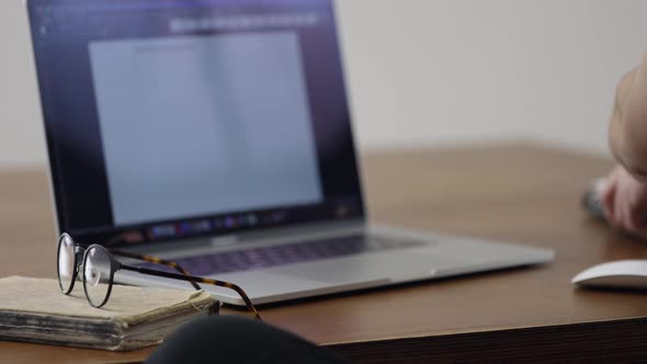 Male hands are working at a laptop and writing notes in a notebook. Work or study process