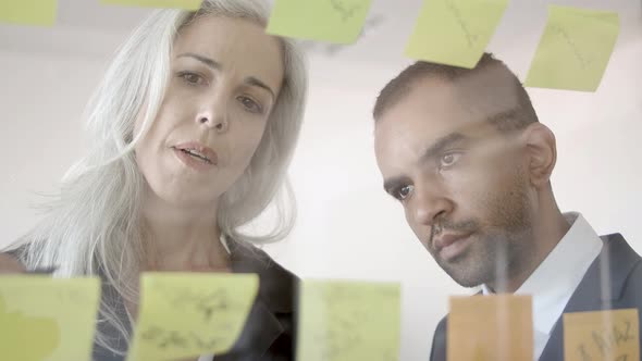 Focused Business Man and Woman Planning Tasks