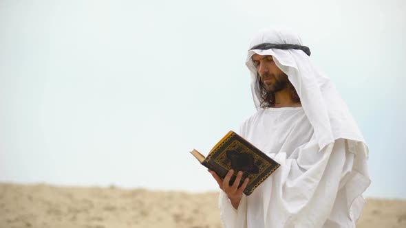 Arab Reading Koran in Desert, Meditating and Reflecting on Muhammad Teachings