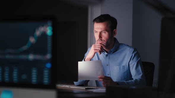 Caucasian adult businessman working in office at night. Shot with RED helium camera in 8K.