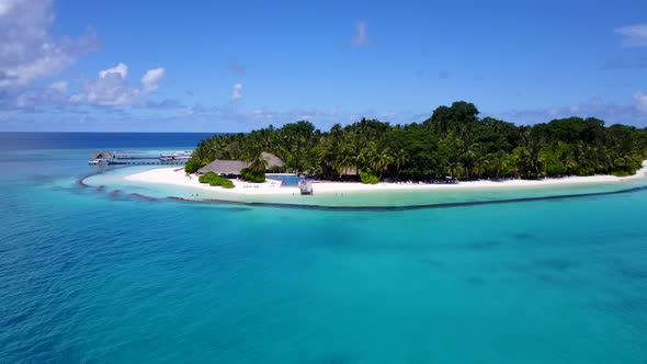 Daytime flying abstract view of a sunshine white sandy paradise beach and aqua blue ocean background