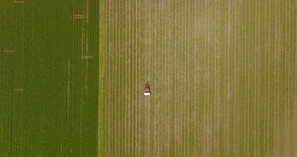 Fertilizer spreader in a large field, Aerial follow footage.