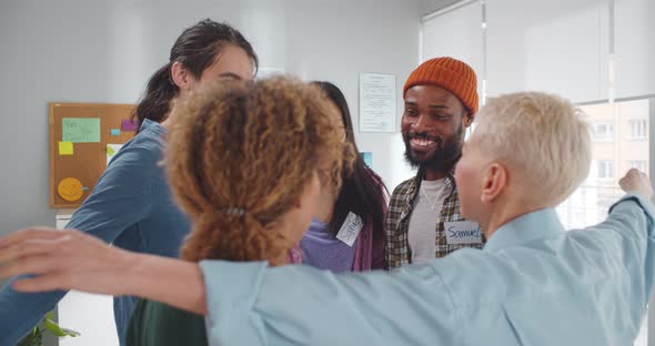 Multiethnic Positive People Hugging During Therapy Session in Support Meeting