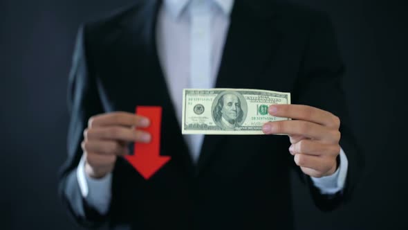 Businessman Showing Dollar Banknote and Red Arrow Sign Falling, Financial Crisis