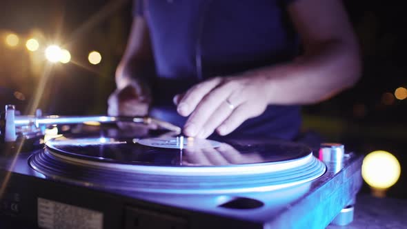 Caucasian DJ in Blue Tshirt Doing Scratching Playing Music at Outdoor Night Pool Party at Night