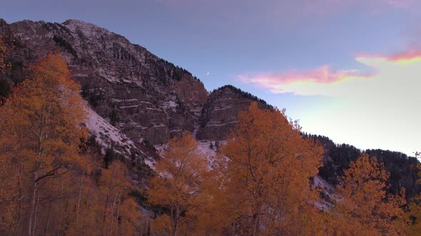 Aerial shot of a colorful mountainside in the fall at sunset.