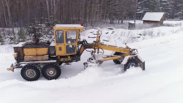 Aerial view of Snowblower Grader Clears Snow Covered Country Road  next to the forest 15