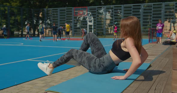 A Girl is Shaking Her Press While Performing a Bicycle Exercise