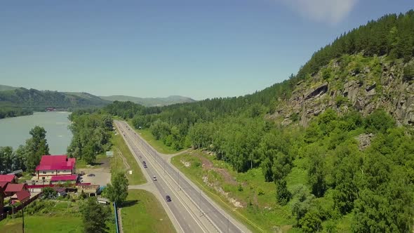 Aerial: Low Level Flying Over the Highway. The View Between the Rock and the Mountain Turquoise