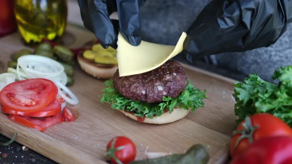 Making Burger  Putting Slice of Cheddar Cheese on a Cutlet