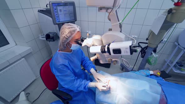 Making laser eye surgery. Surgeon looking into the microscope