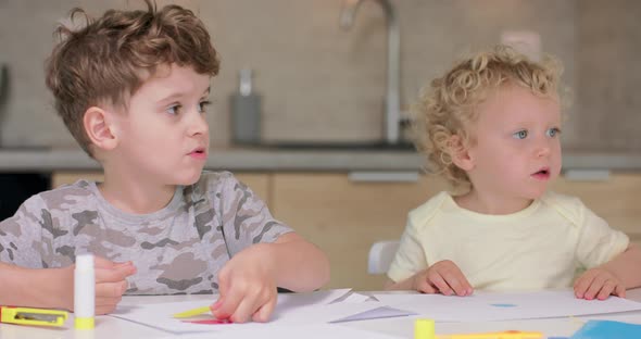 Small Boy Puts the Glue on the Cutted From Paper Objects During Making Applications with Coloured