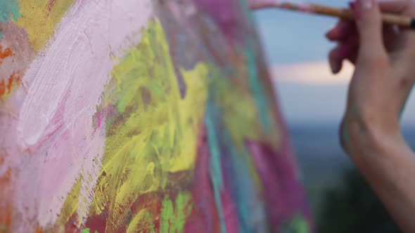 Hand Of An Artist Painting With Pink Paint On Canvas.