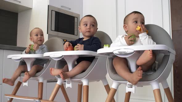 Curious Triplets Biting on Apples and Watching Something