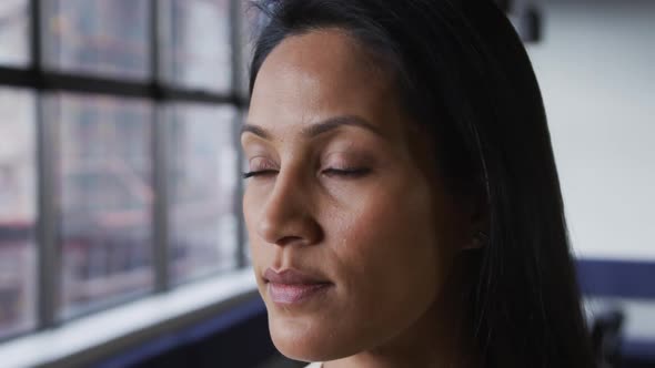 Portrait close up of mixed race businesswoman looking at camera and smiling in office