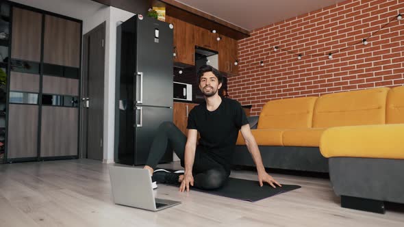 Fitness Male Athlete Practicing Online Exercises on Floor a Mat Using Laptop at Home in Living Room