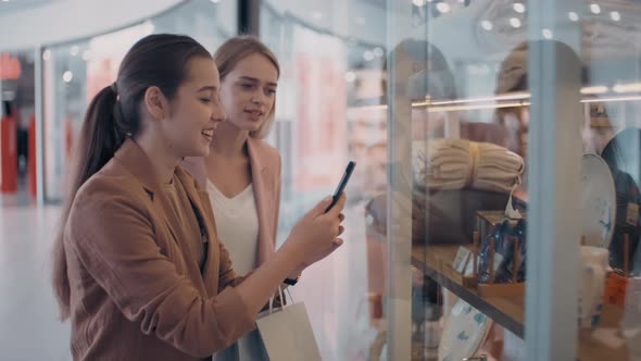 Happy Women Taking Photo of Home Decor in Store Window