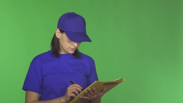 Young Delivery Woman Checking Papers on a Clipboard Smiling To the Camera