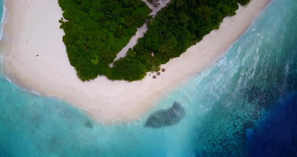 Daytime fly over tourism shot of a white sand paradise beach and blue ocean background in colourful 