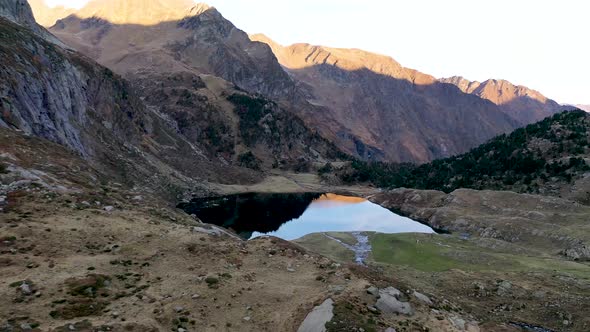 Lac d'Espingo mountain runoff lake located in Haute-Garonne, Pyrénées, France, Aerial flyover approa