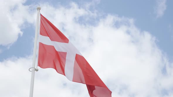 Denmark national flag in front of cloudy sky waving 4K 2160p 30fps UHD footage - Red and white  Dani alt