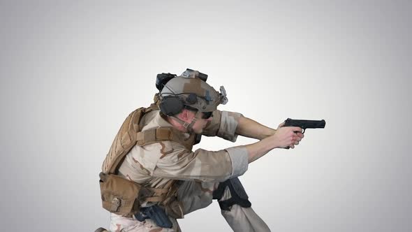 Soldier Is Shooting From Pistol Sitting on His Knee on Gradient Background.