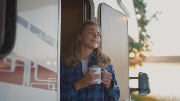 Caucasian Female is Resting in Nature Near the Lake Standing Near a Mobile Home and Enjoying Nature