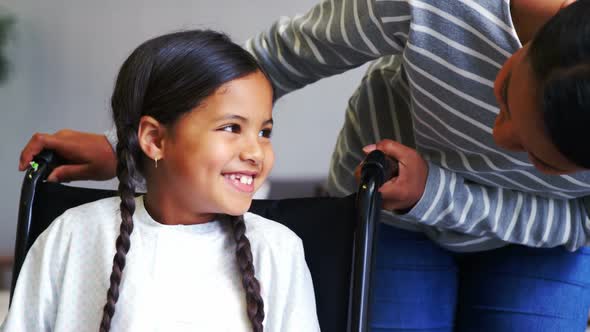 Mother interacting with girl in wheel chair