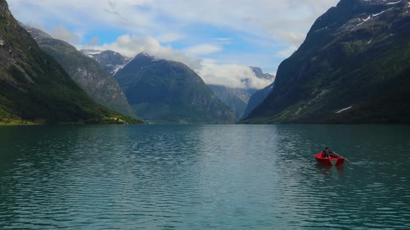 Woman on the boat catches a fish on spinning in Norway.