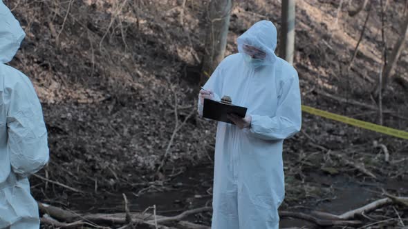 Forensic specialists working in the forest. Crime scene and police concept.