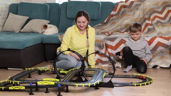 Mom and Little Son Play Racing on the Carpet at Home Have Fun and Hug