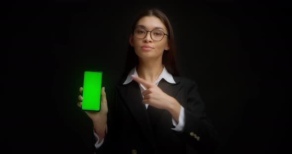 Business Lady in Glasses Shows Vertical Green Phone Screen for Copying